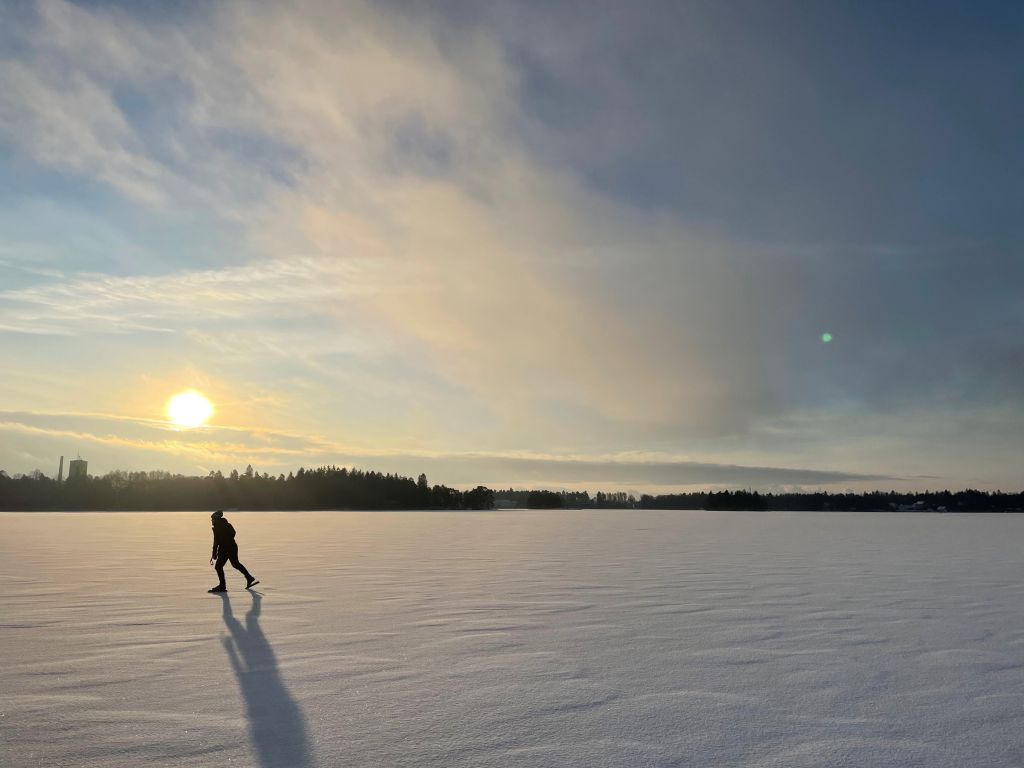 Luistelija jäällä talven valossa